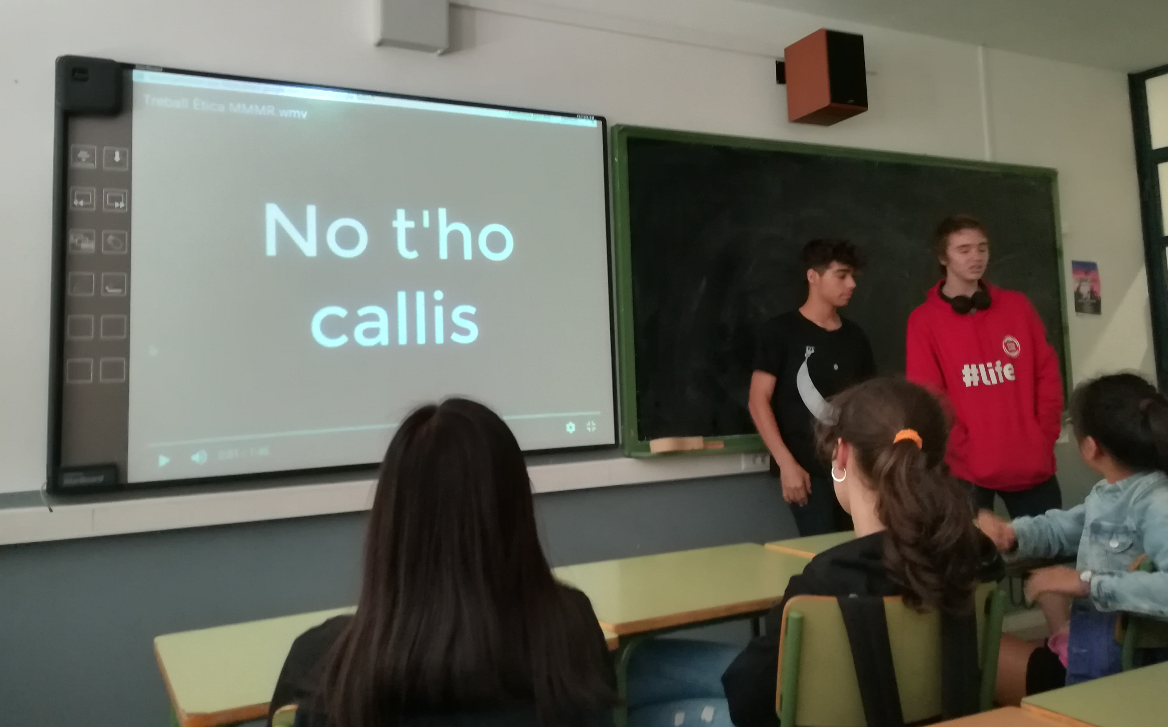 dos nois presentant el seu projecte audiovisual a l'aula